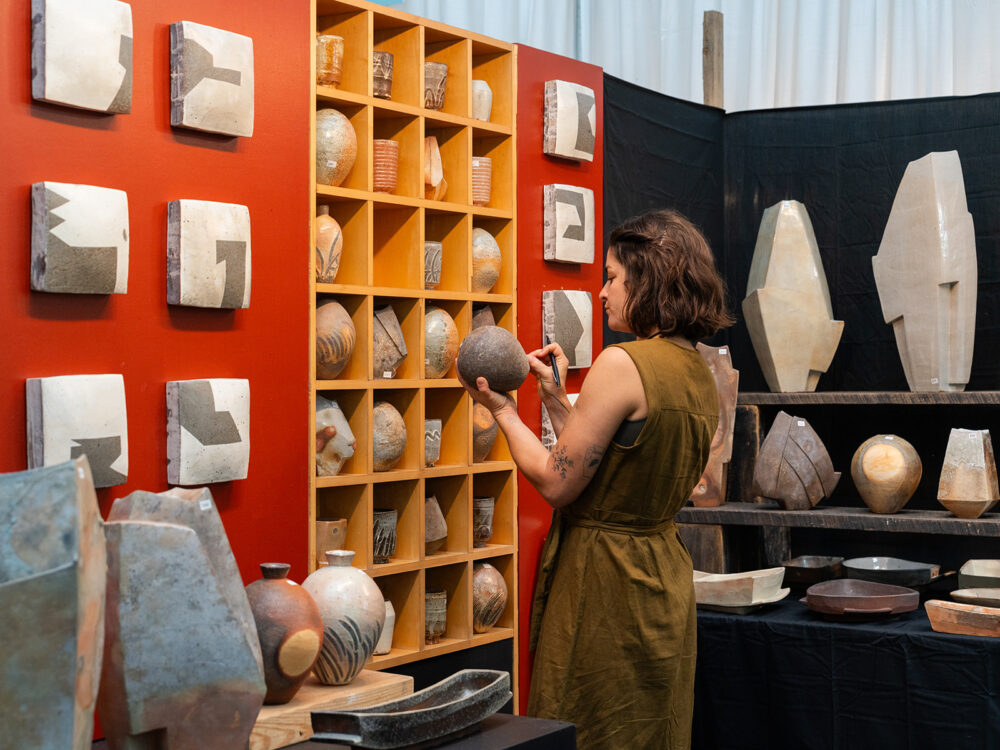 Person holding a piece of pottery in a Potters Market at the Mint stall